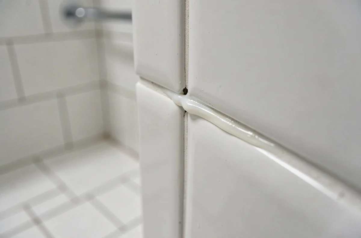 Joint mal étanche entre deux plaques PVC de salle de bain avec silicone mal appliqué